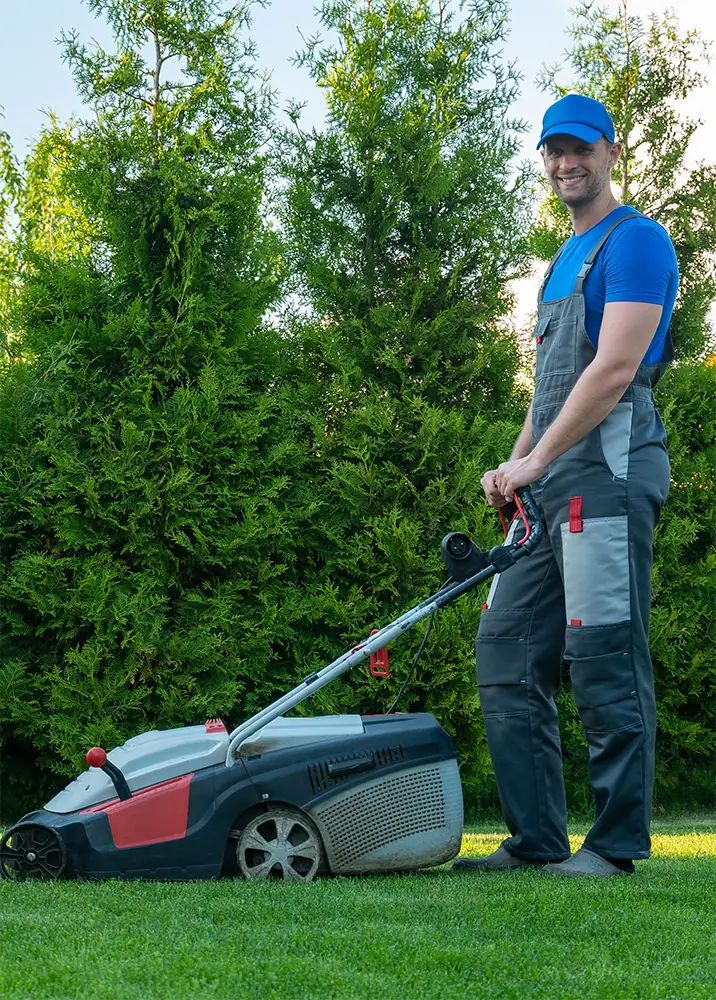 young-gardener-overalls-uses-lawn-mower-plot